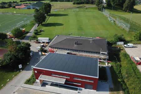 Eine grosse Sporthalle von oben fotografiert. Das Dach ist mit Solarzellen bedeckt. 