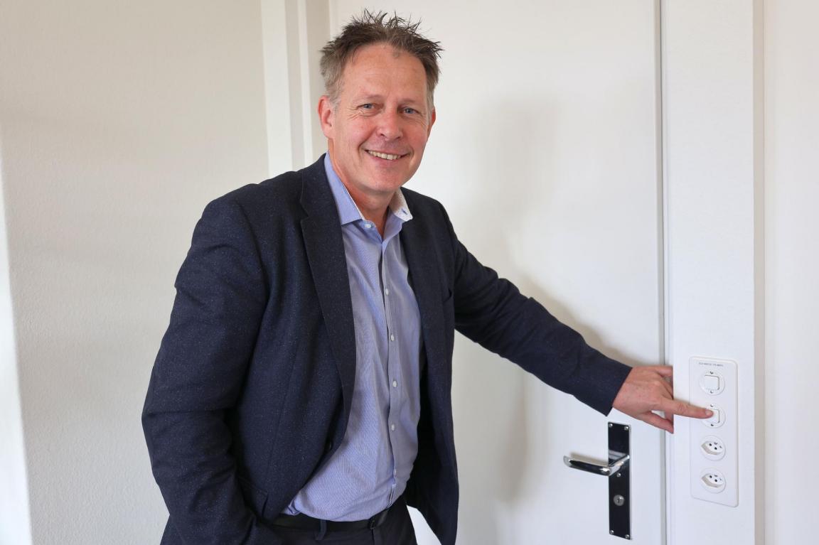 Christoph Zemp, der Amtschef des AWEL, steht vor seinem Büroausgang und drückt mit dem Finger auf den Lichtschalter zum Lichterlöschen.