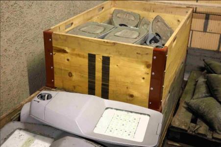 In zwei hölzernen Palettkisten sind neue Lampenköpfe zu sehen. Sie haben auf ihrer Unterseite eine grosse Leuchtfläche mit LED-Lichtern.