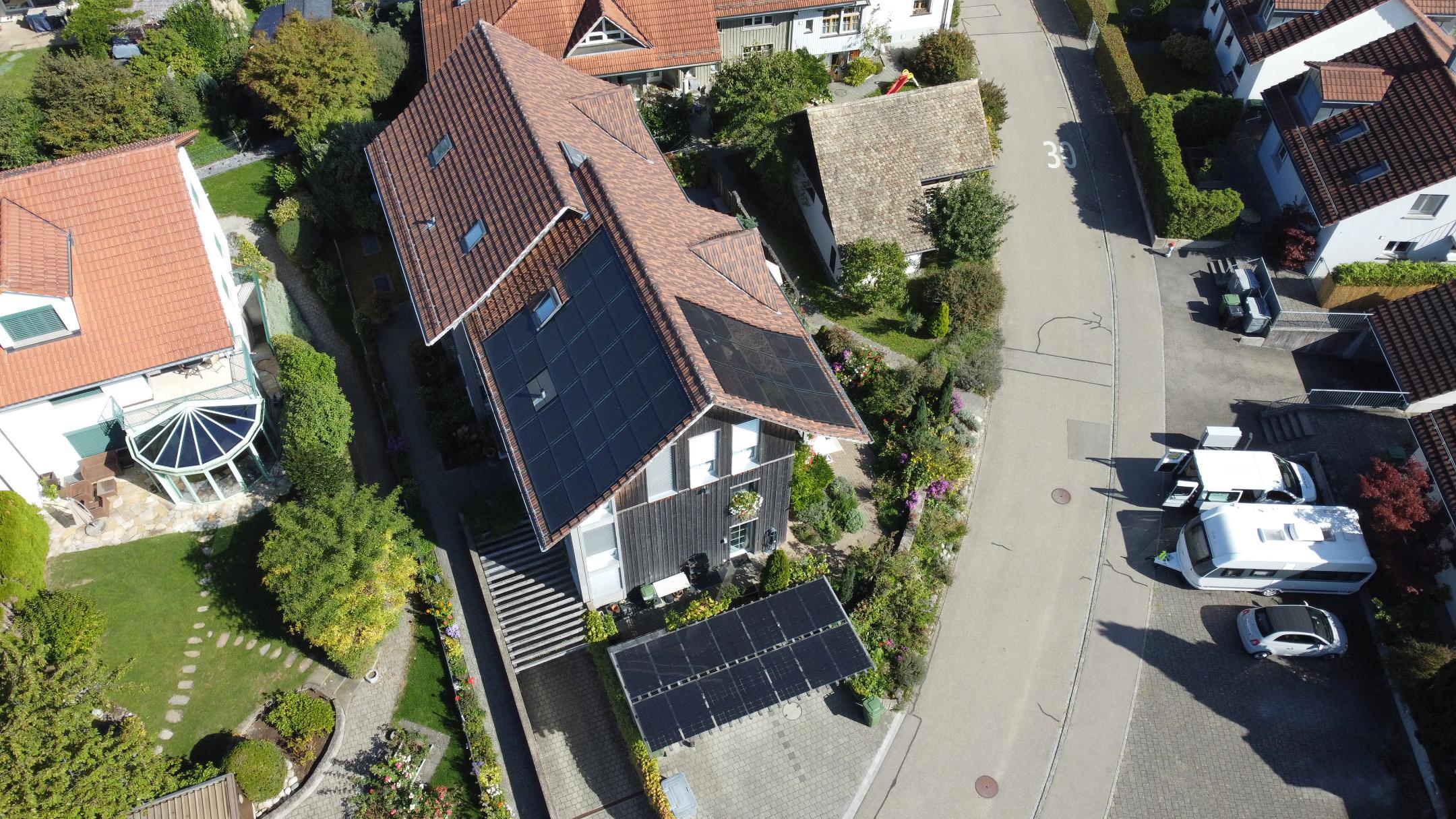 Auf einer Luftaufnahme sieht man verschiedene Häuser. Auf einem der Hausdächer befinden sich Solarzellen. 
