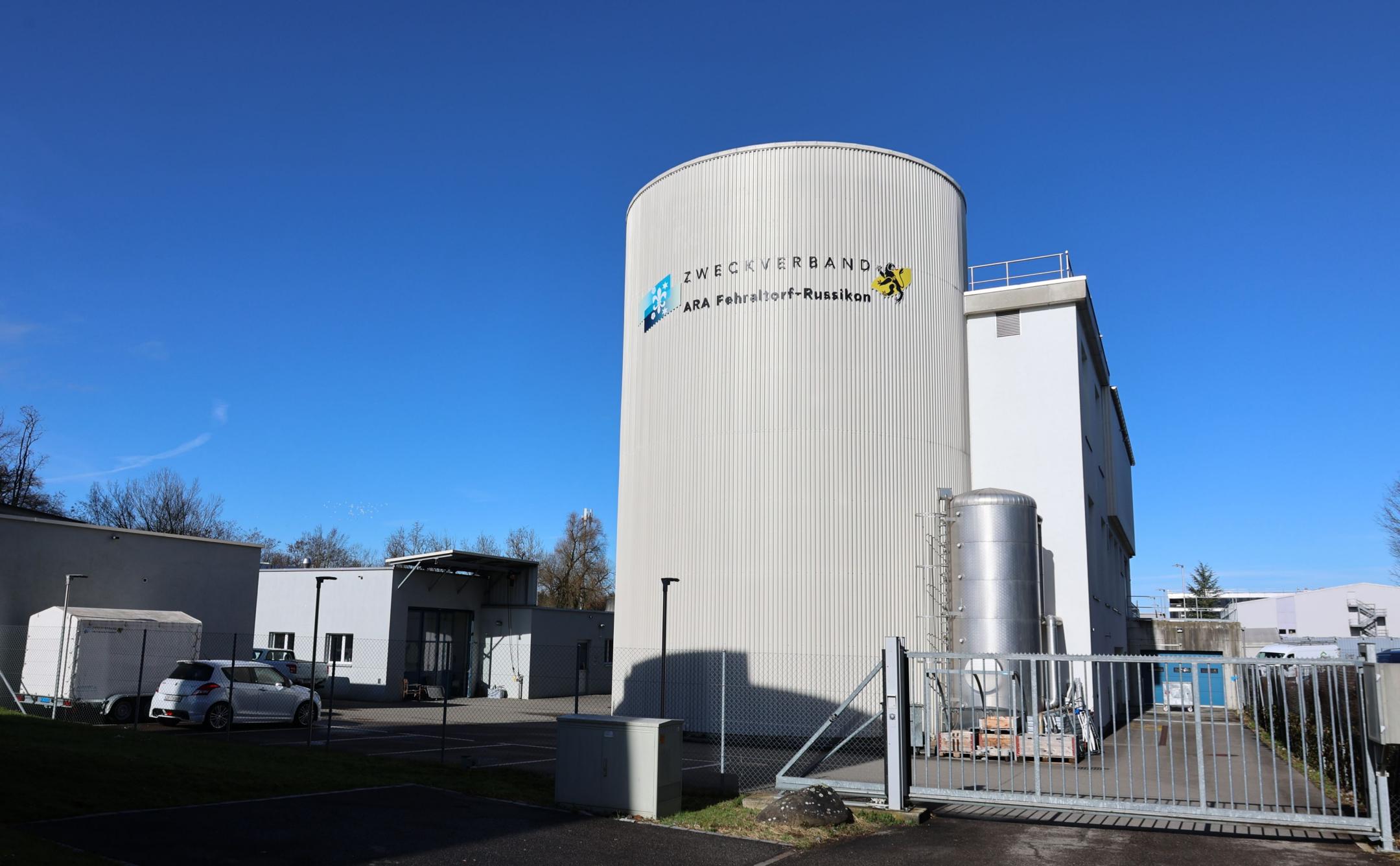 Das Gelände der Abwasserreinigungsanlage Fehraltorf. Es sind mehrere Gebäude, unter anderem ein grosser Wassertank, zu sehen.  