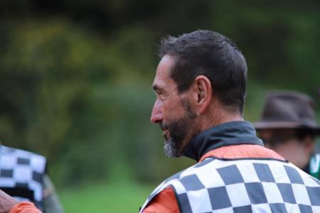 Markus Meile in einer Profilansicht. Er trägt eine rote Jacke und eine schwarz-weisse Weste mit der Aufschrift Übungsleiter. 