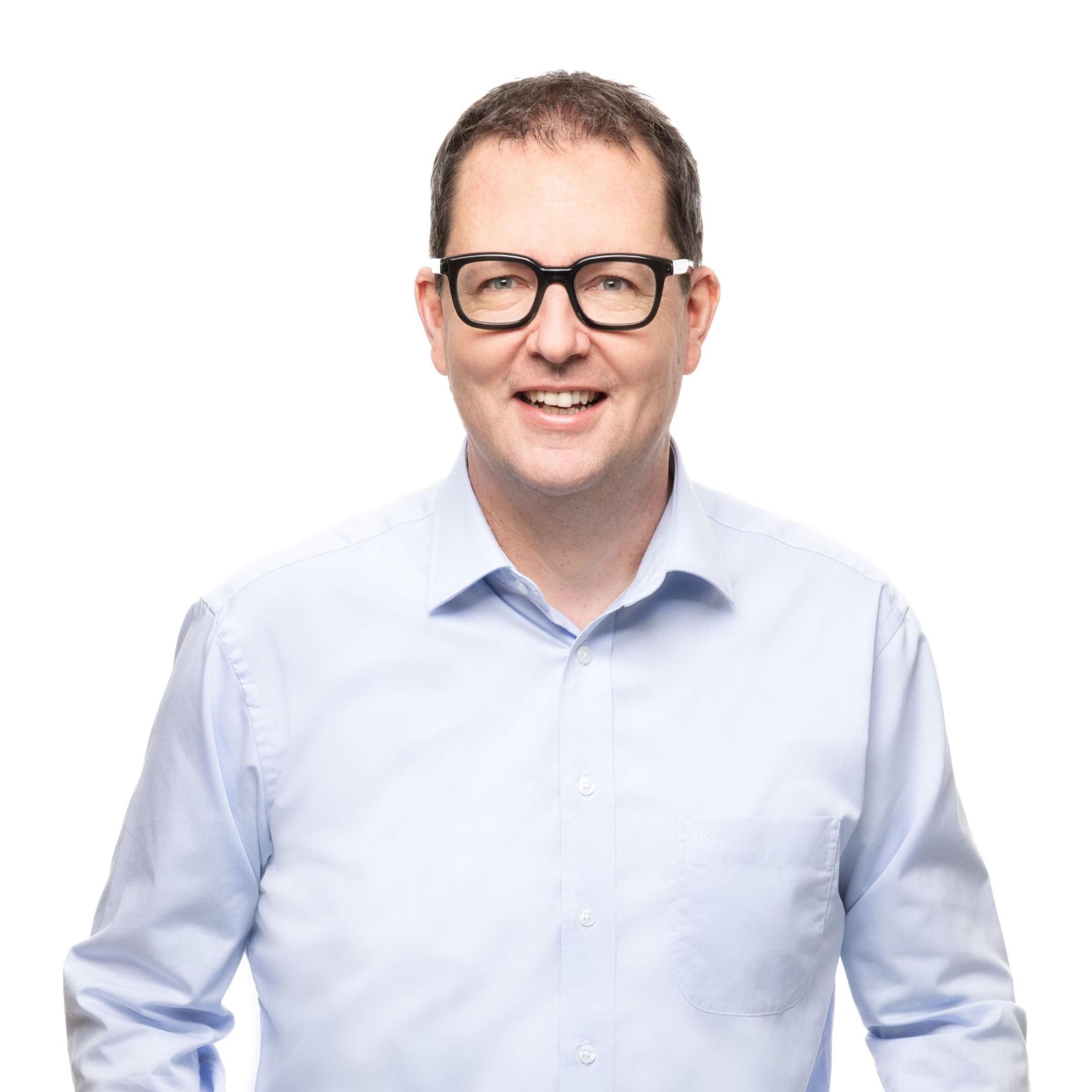 Portraitfoto von Stefan Mathys. Der Leiter der Fehraltorfer Werke hat braune Haare, trägt eine schwarzumrandete Brille, ein hellblaues Hemd und Jeans.