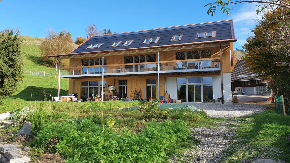 Aufnahme des des Mehrfamilienhauses Schwalbenhof der Genossenschaft WAK nach dem Umbau. Sichtbar ist die Photovoltanlage auf dem Dach.