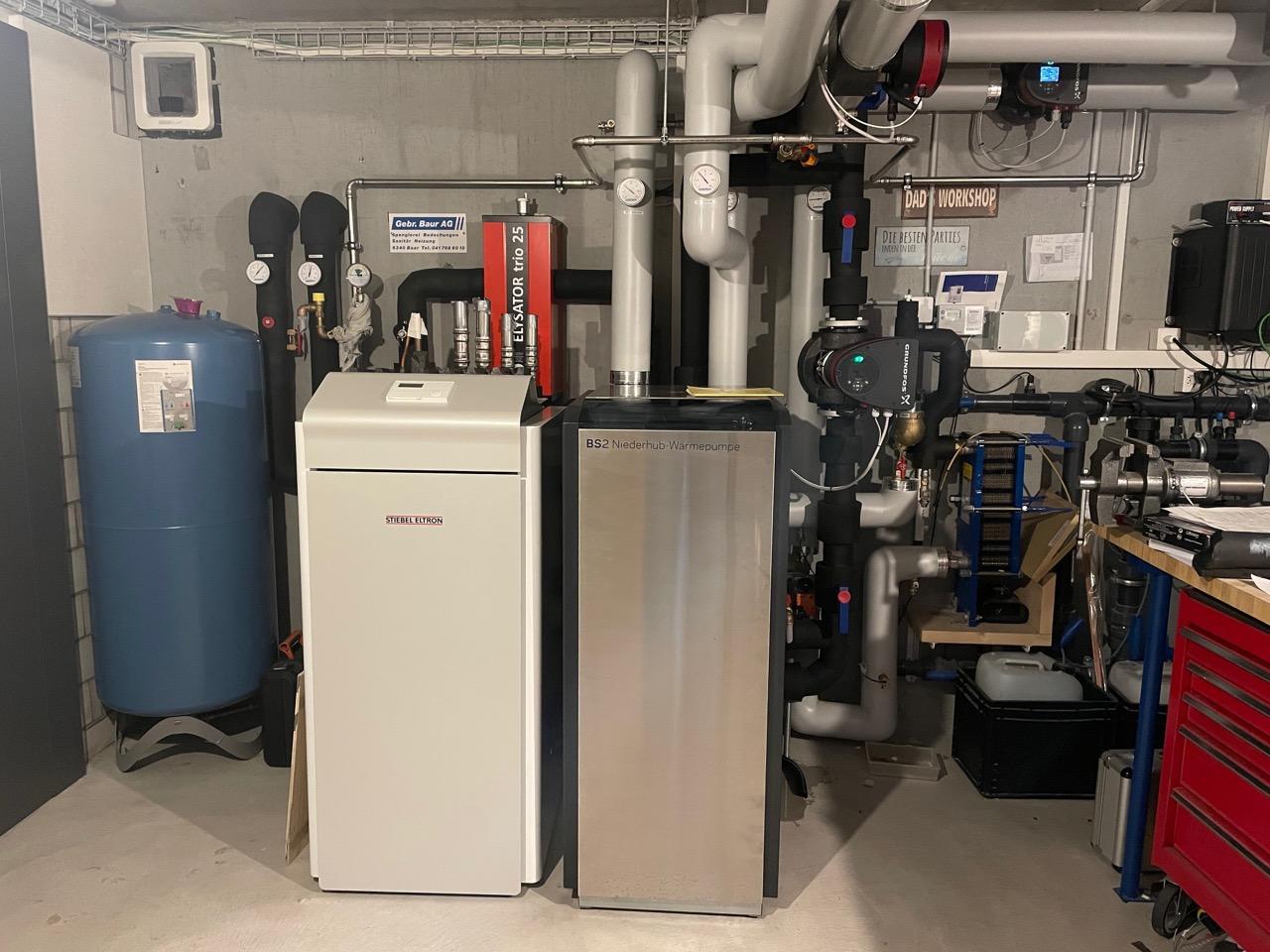 Aufnahme im Heizungsraum mit Provisorischer Wärmepumpe (links) und neuer Niederhub-Wärmepumpe (rechts)