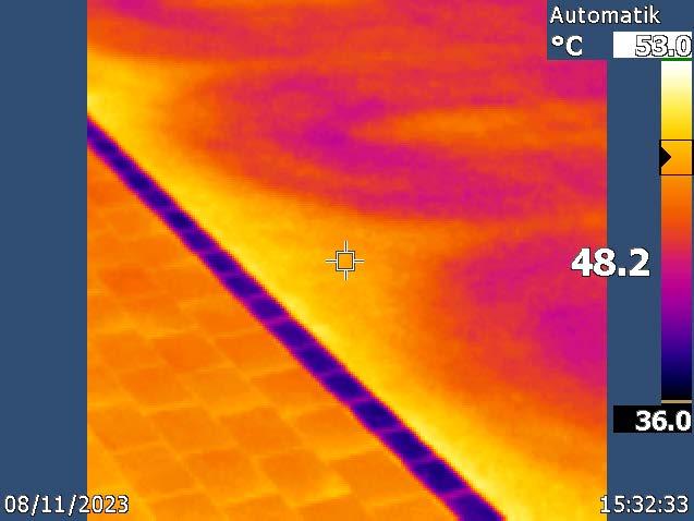 Thermografieaufnahme einer Asphaltfläche, auf der sich der gekühlte Bereich als hellgelbe Zone von der umgebenden orange dargestellten, wärmeren Fläche abhebt. Die Messstelle zeigt 48.2 °C bei einer Skala von 36 bis 53 °C.
