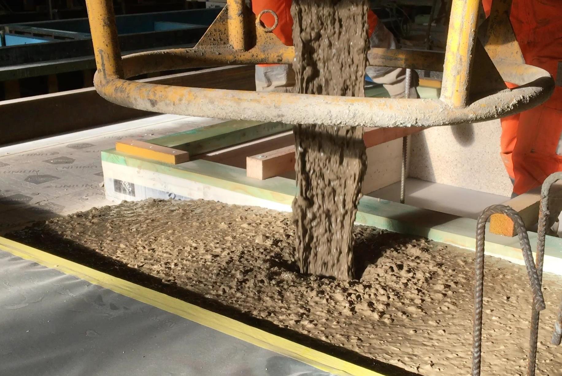 Schüttung von Oulesse-Beton mittels eines konventionellen Betondosierers. Die Verarbeitung des Oulesse Betons erfordert keine Anpassung der Gerätschaften in der Bauwirtschaft, was ein grosser Vorteil für die Verbreitung der Anwendung zementfreien Produkte darstellt. 