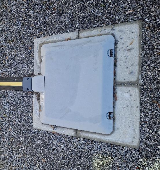 Nahaufnahme des induktiven Ladepads auf einem Parkplatz, eingebettet in den Asphalt..