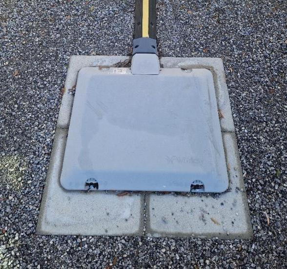 Nahaufnahme des induktiven Ladepads auf einem Parkplatz, eingebettet in den Asphalt..