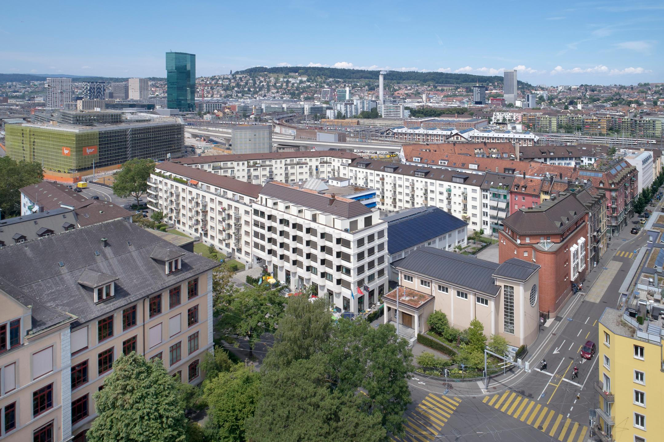 Luftaufnahme der Liegenschaft Hohlstrasse 100 mit dem Randgebäude im Vordergrund und dem dahinterliegenden Hofgebäude mit Photovoltaikanlage auf dem Dach.