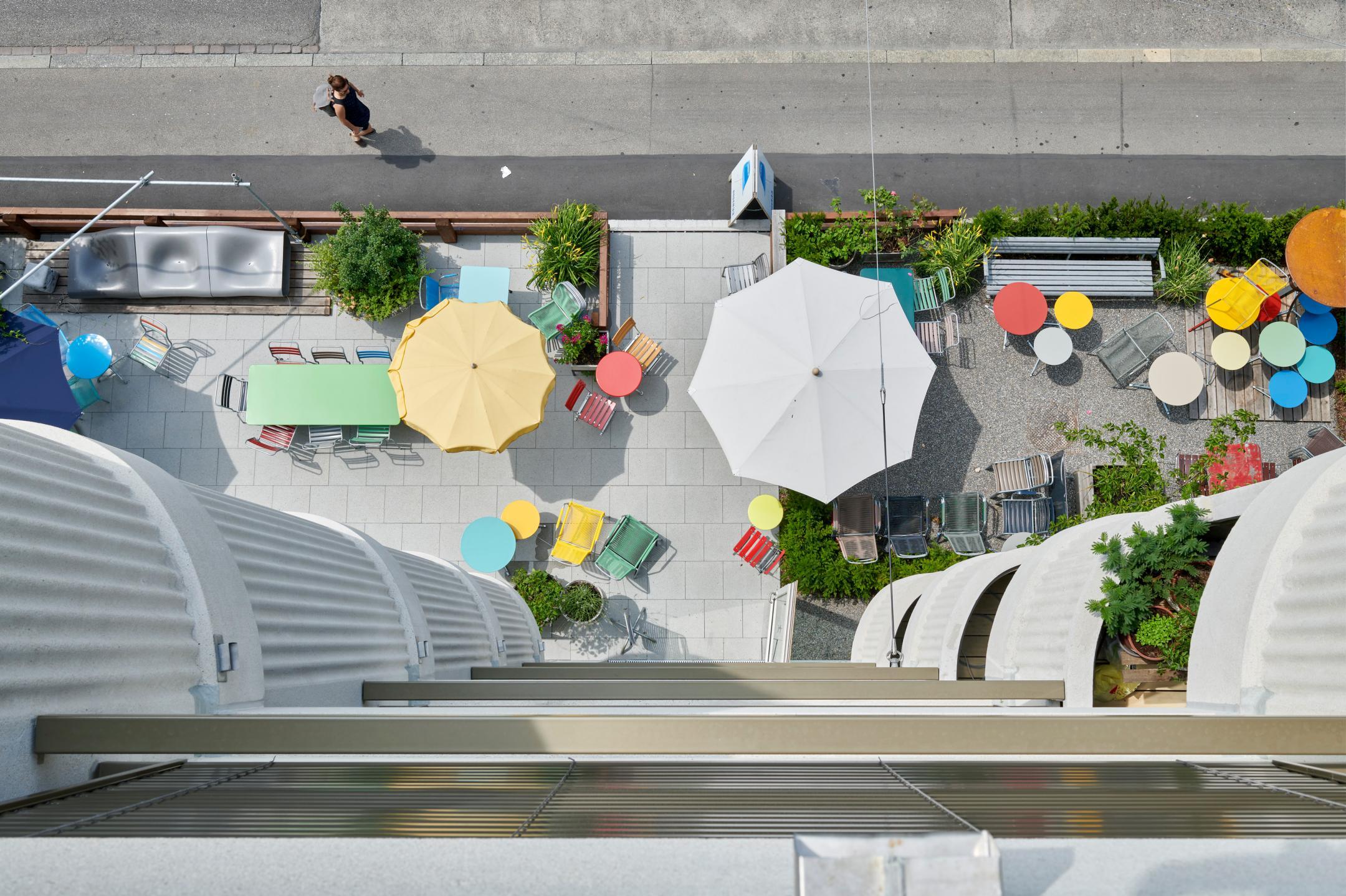 Blick von oben die Fassade des Randgebäudes an der Hohlstrasse 100 hinunter, mit Aerogeldämmung und halbkreisförmig auskragenden Balkonen.