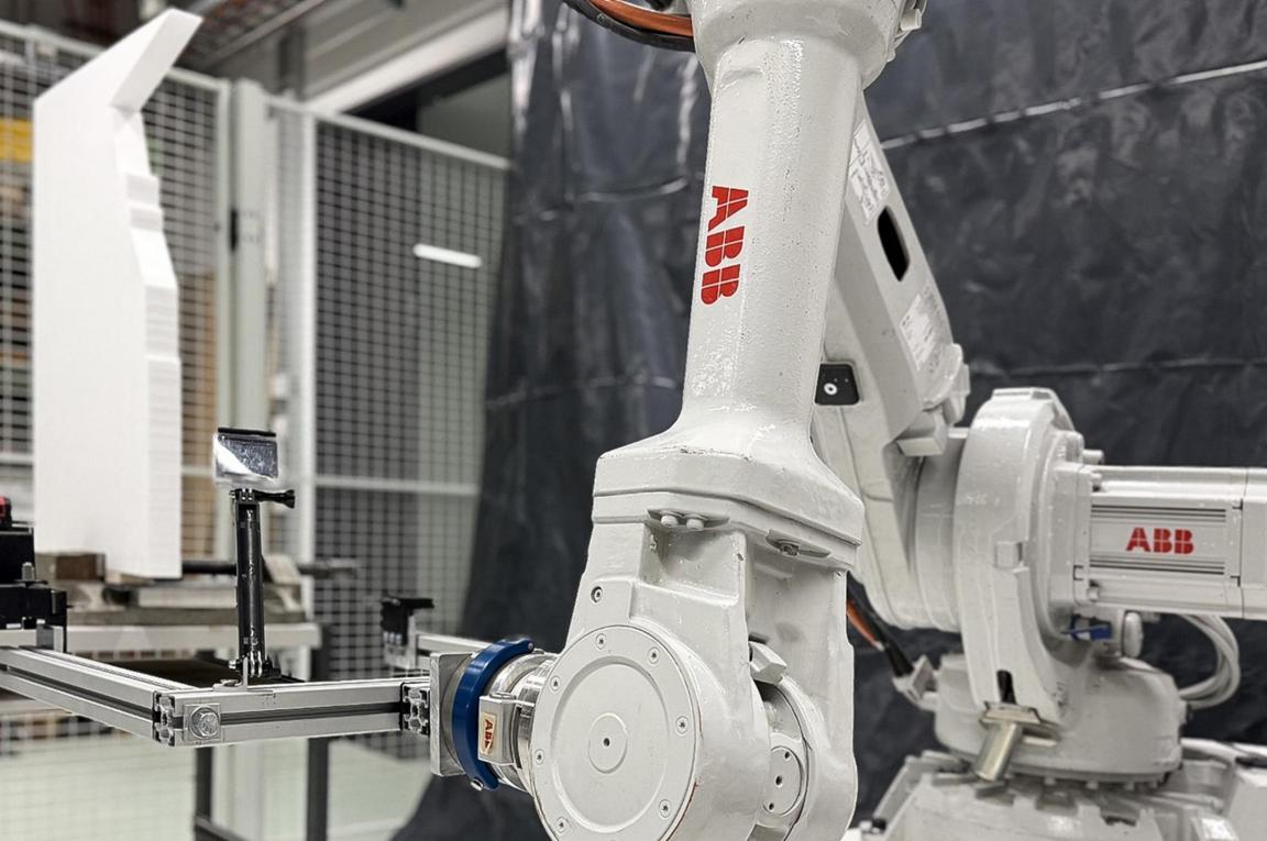 Ein weisser Roboterarm in einer Fertigungshalle