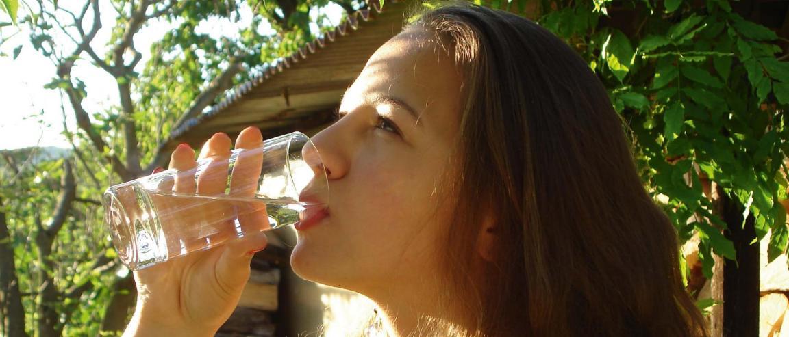 Eine junge Frau trinkt ein Glas Wasser