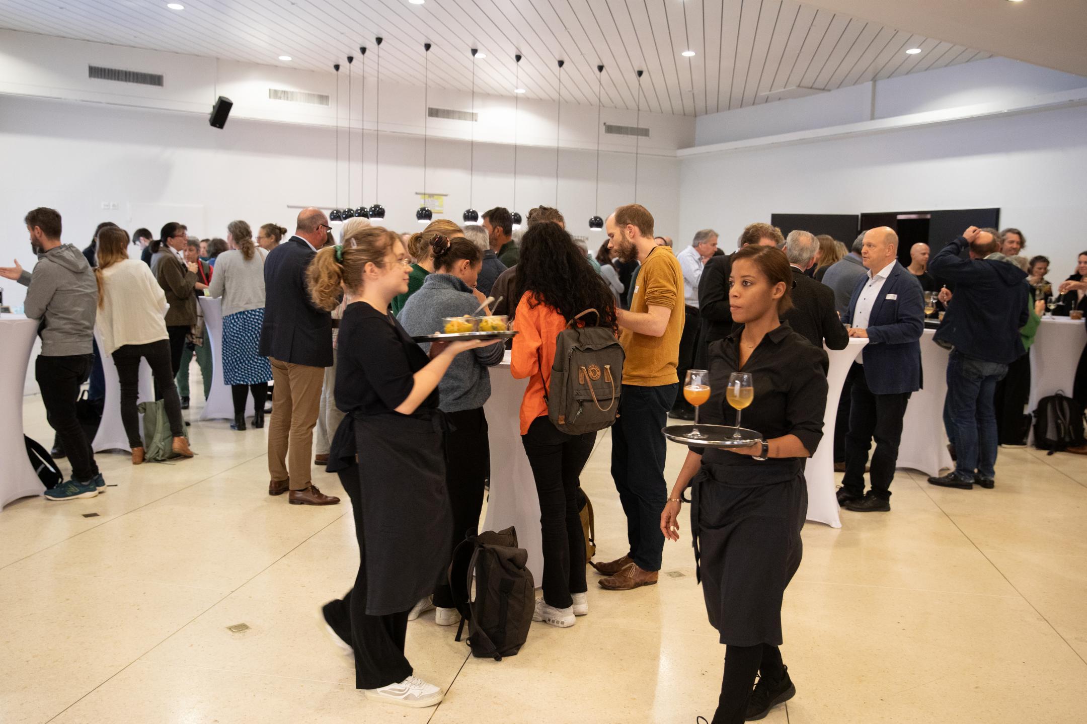 Die Personen stehen zusammen beim Apéro