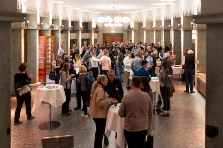 Personen stehen in Vorraum an Apérotischen