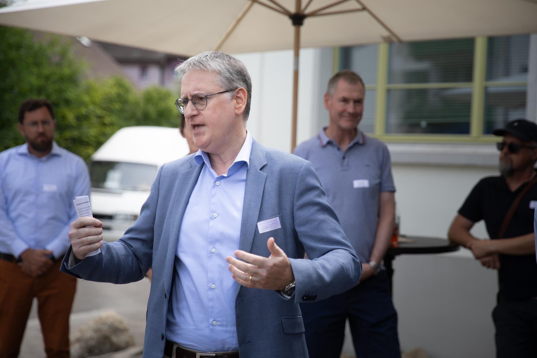 Stadtpräsident bei Begrüssung, Teilnehmende im Hintergrund