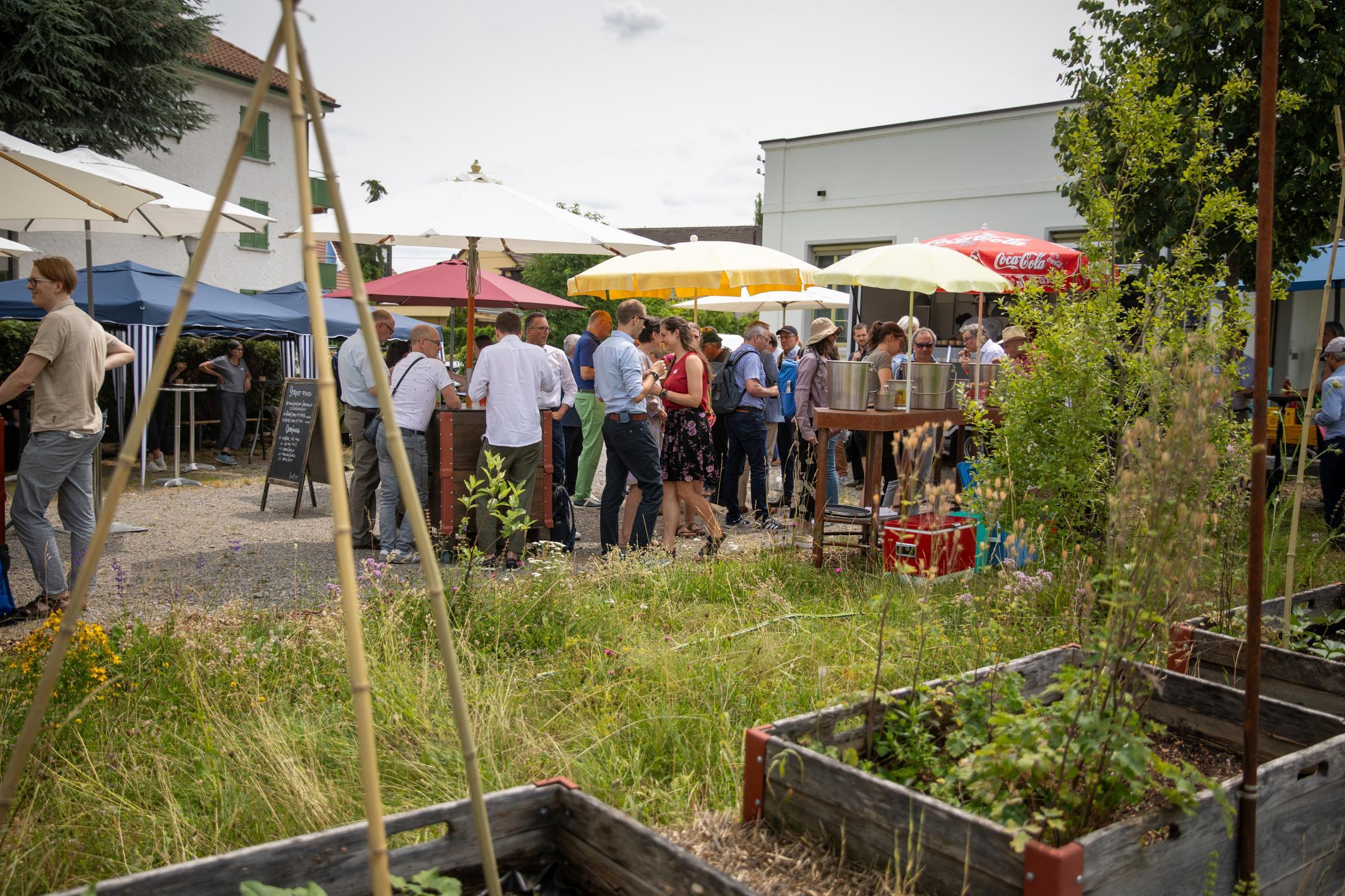 Mehrere Personen im Freien unter Sonnenschirmen