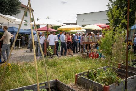 Mehrere Personen im Freien unter Sonnenschirmen
