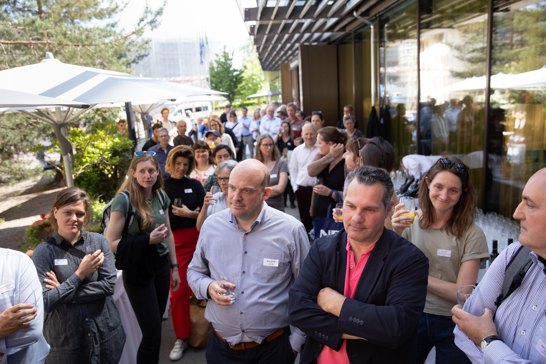 Teilnehmende hören am Apéro den Ansprachen zui