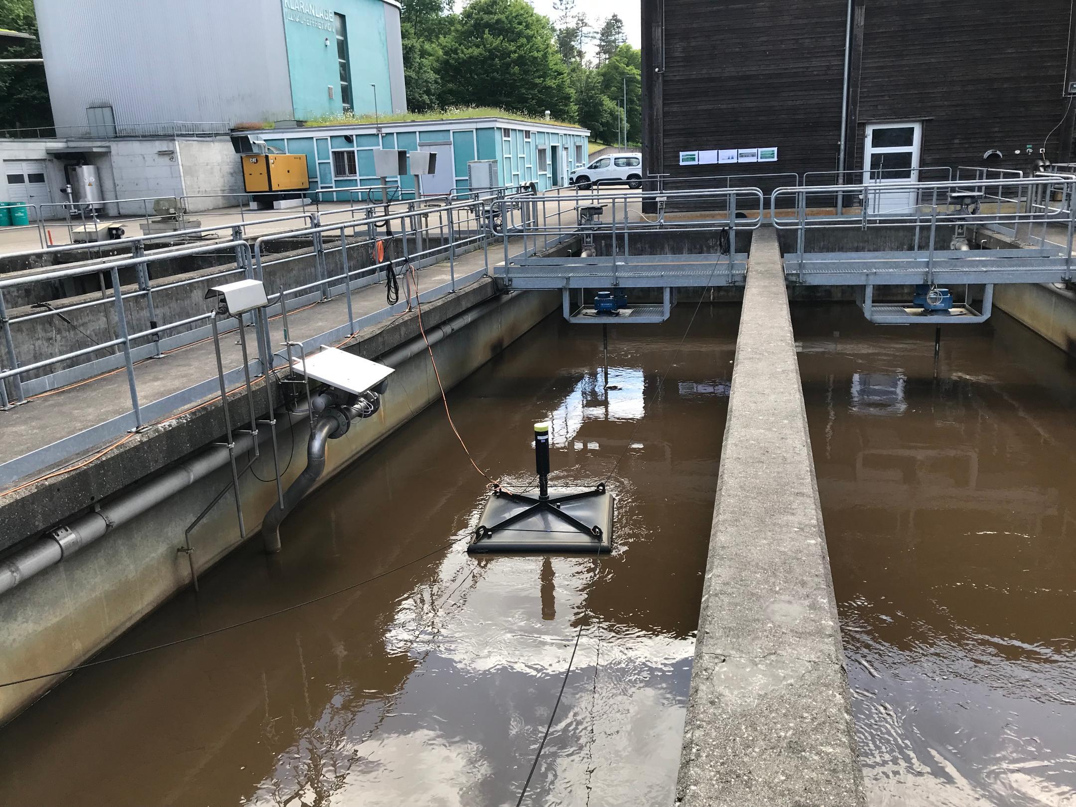 Klärbecken mit einer viereckigen Messhaube, die drauf schwimmen.