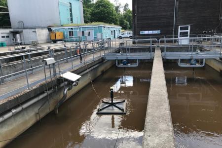 Klärbecken mit einer viereckigen Messhaube, die drauf schwimmen.