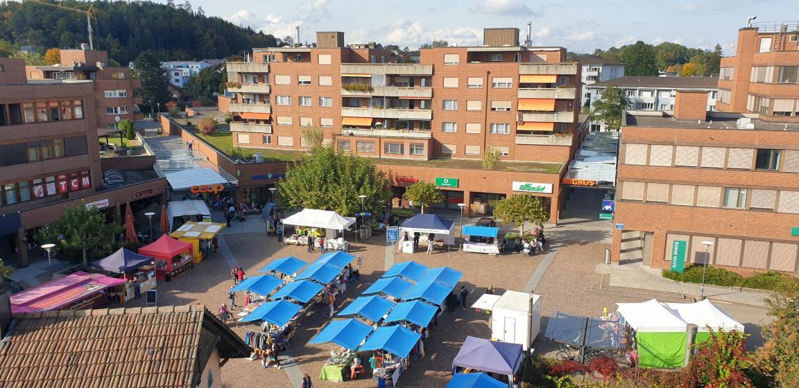 Platz mit Marktständen, umgeben von Gebäuden