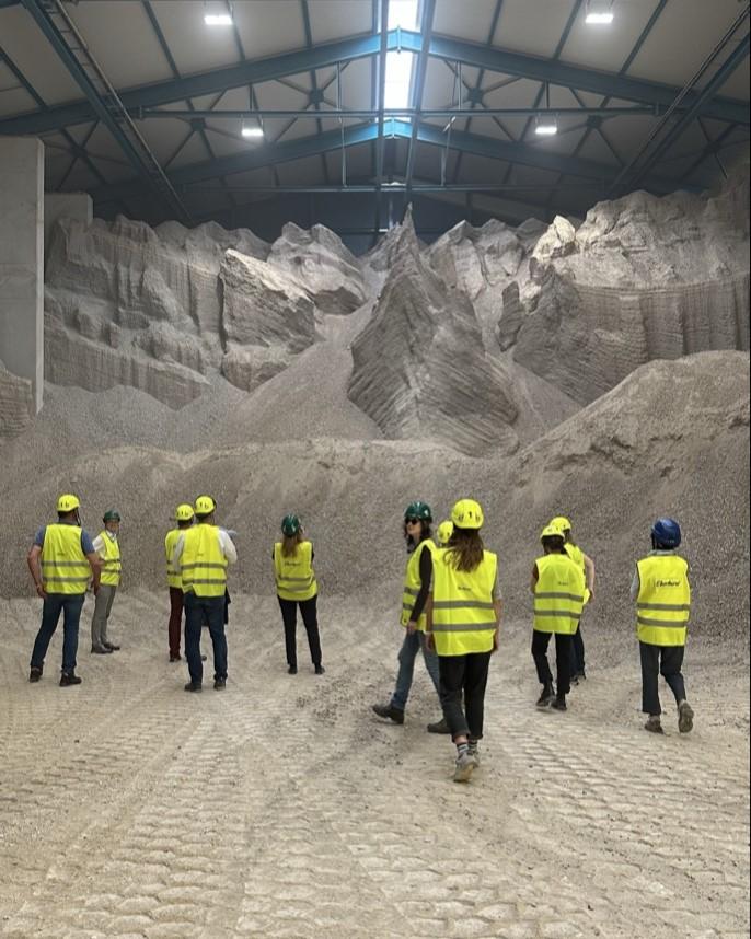 Teilnehmende des Klimadialogs 2025 in Leuchtwesten und mit Helmen auf dem Kopf besichtigen eine Halle mit recycelten Bauabfällen im  Aufbereitungszentrum der Eberhard Unternehmungen.