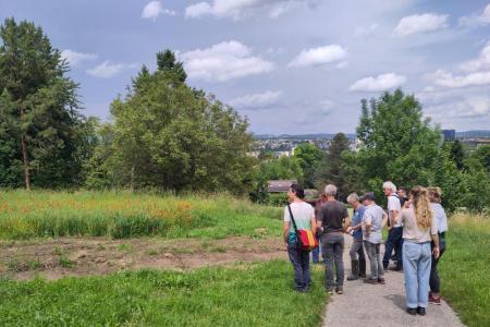Gruppe neben einem Feld des Huebhofs stehend.