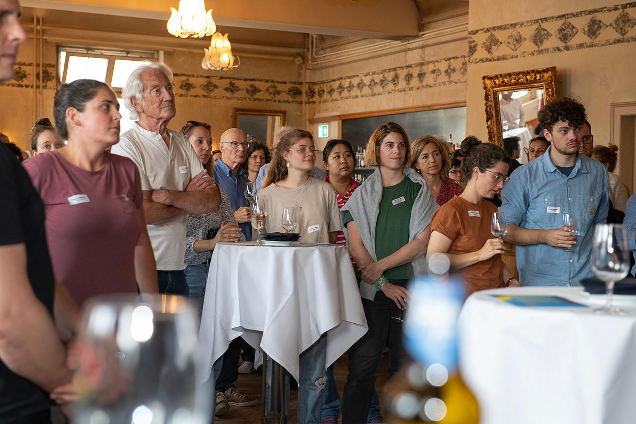 Teilnehmende des Klimadialogs vor Ort 2025 an Stehtischen stehend am Apéro Riche im Restaurant Saal / La Stazione.