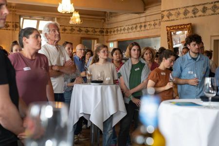 Teilnehmende des Klimadialogs vor Ort 2025 an Stehtischen stehend am Apéro Riche im Restaurant Saal / La Stazione.