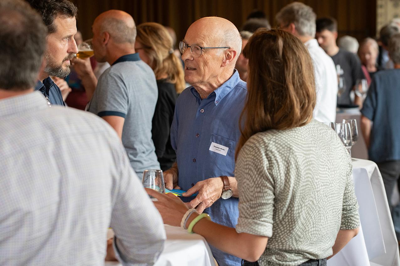 Teilnehmende des Klimadialogs beim Apéro Riche in Dübendorf an Stehtischen im Gespräch.