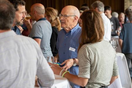 Teilnehmende des Klimadialogs beim Apéro Riche in Dübendorf an Stehtischen im Gespräch.