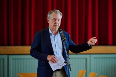 Person vor Mikrofon mit Notizzettel