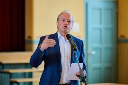 Person vor Mikrofon mit Notizen
