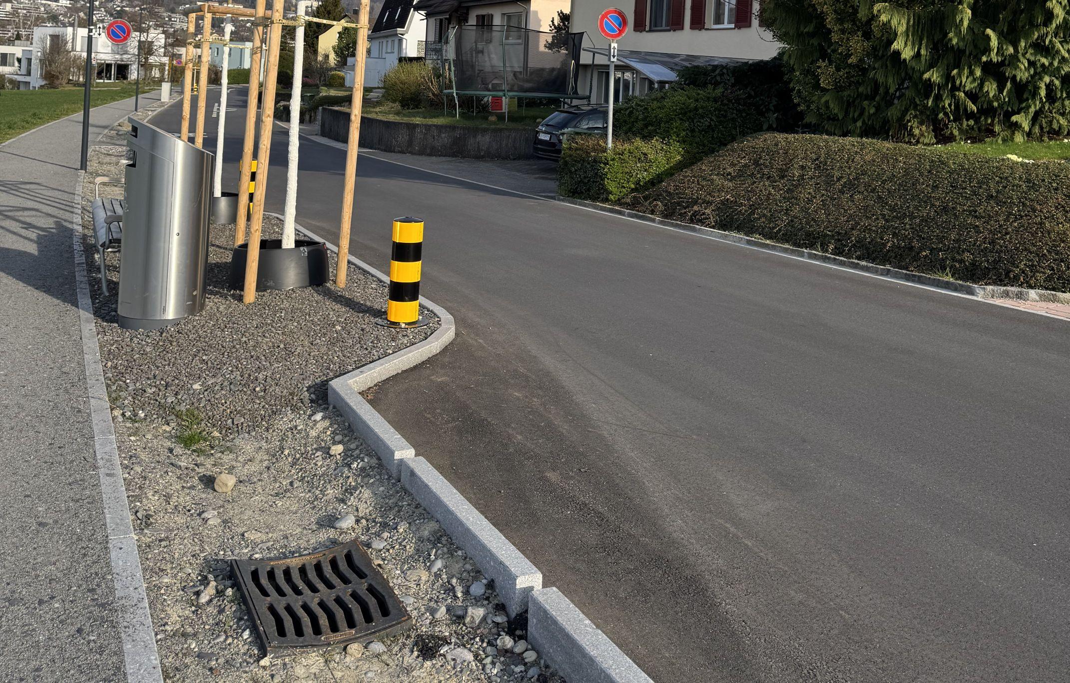 Das Foto zeigt einen neu sanierten Strassenabschnitt, wo das Wasser über durchlässige Randabschlüsse in einen Grünstreifen versickern kann. 
