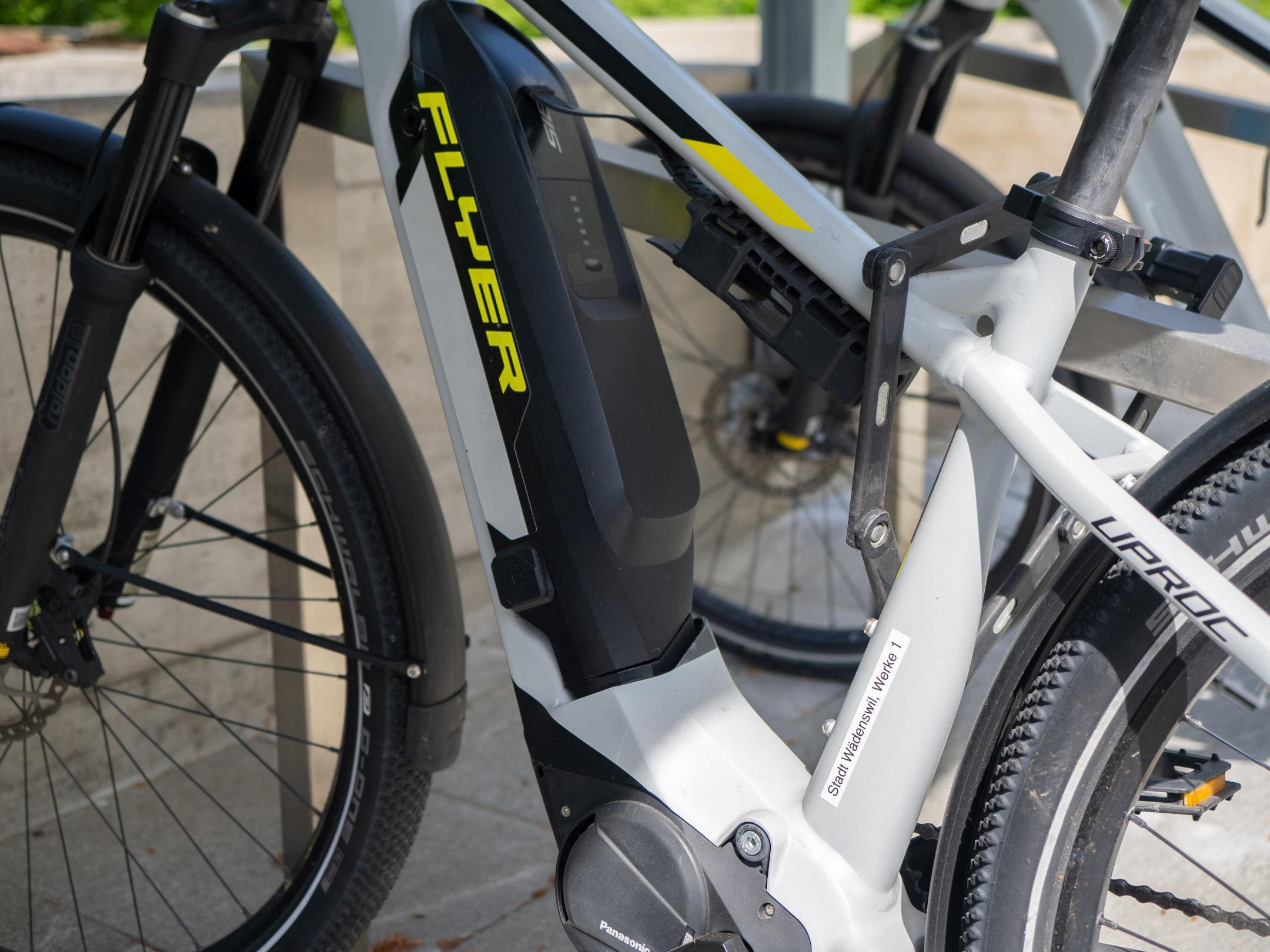 Der Akku eines E-Bikes. Im Hintergrund ein weiteres E-Bike.