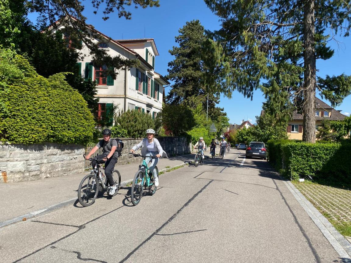 Eine Gruppe Jugendlicher fährt auf dem Velo durch ein Wohnquartier in Männedorf. 