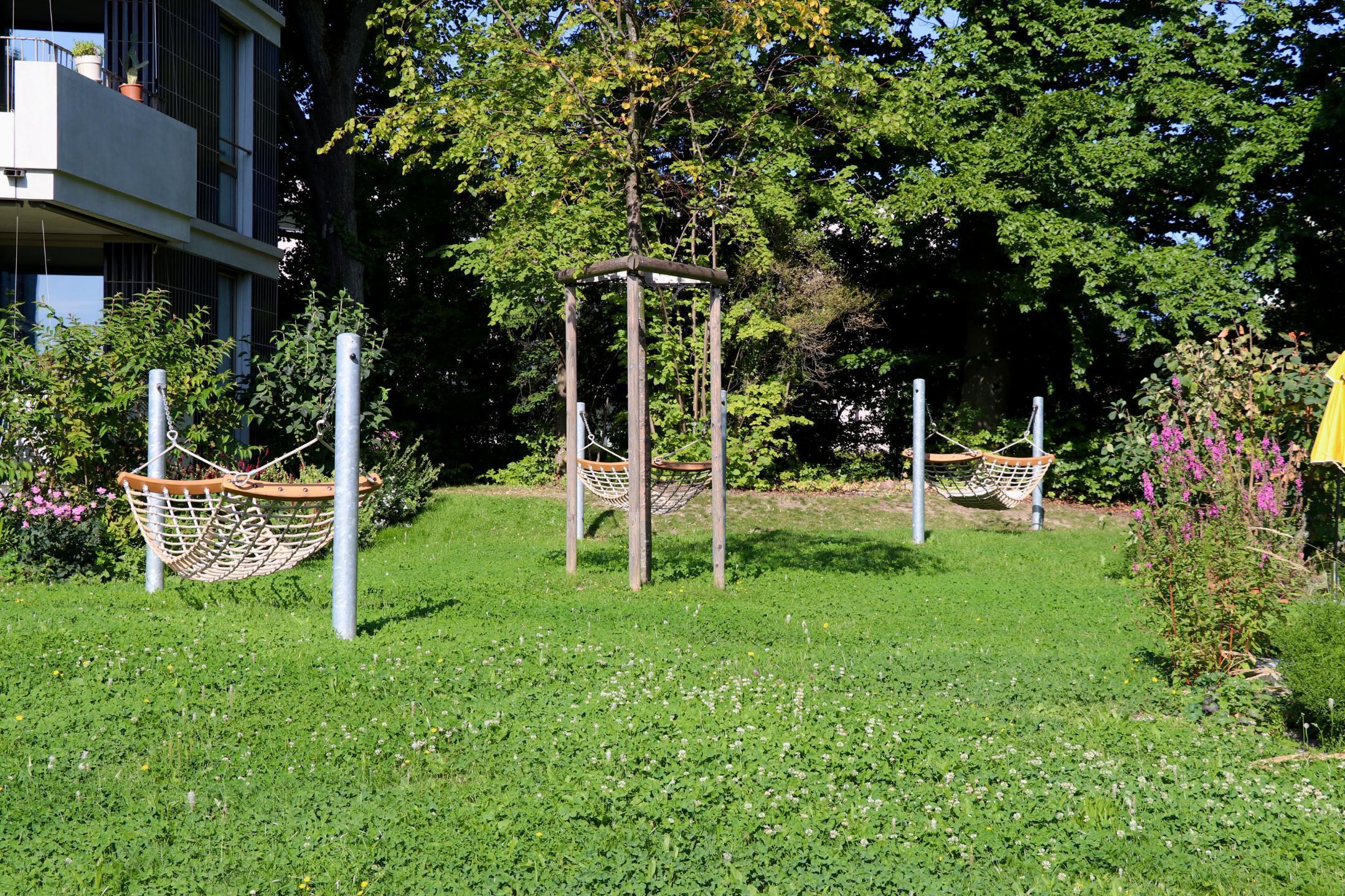 Zwischen den Häuser der Bellaria Siedlung in Zürich ist ein Blumenrasen ersichtlich, welcher belastbar ist.