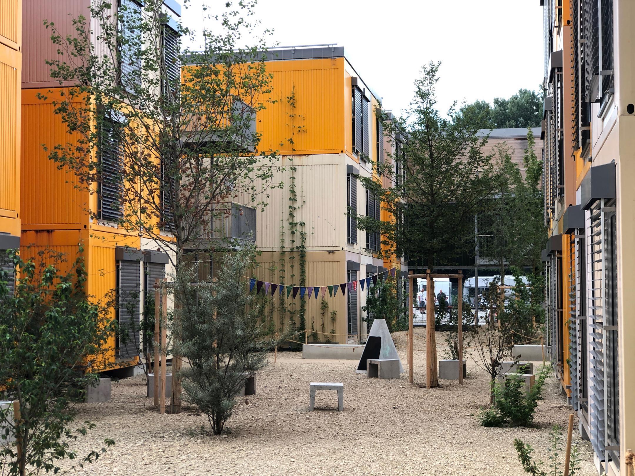 Auf dem Bild sind die Wohncontainer des Fogo Areals in Zürich zu sehen. Die Fläche rund um die Container ist entsiegelt und besteht aus hellem Kies.