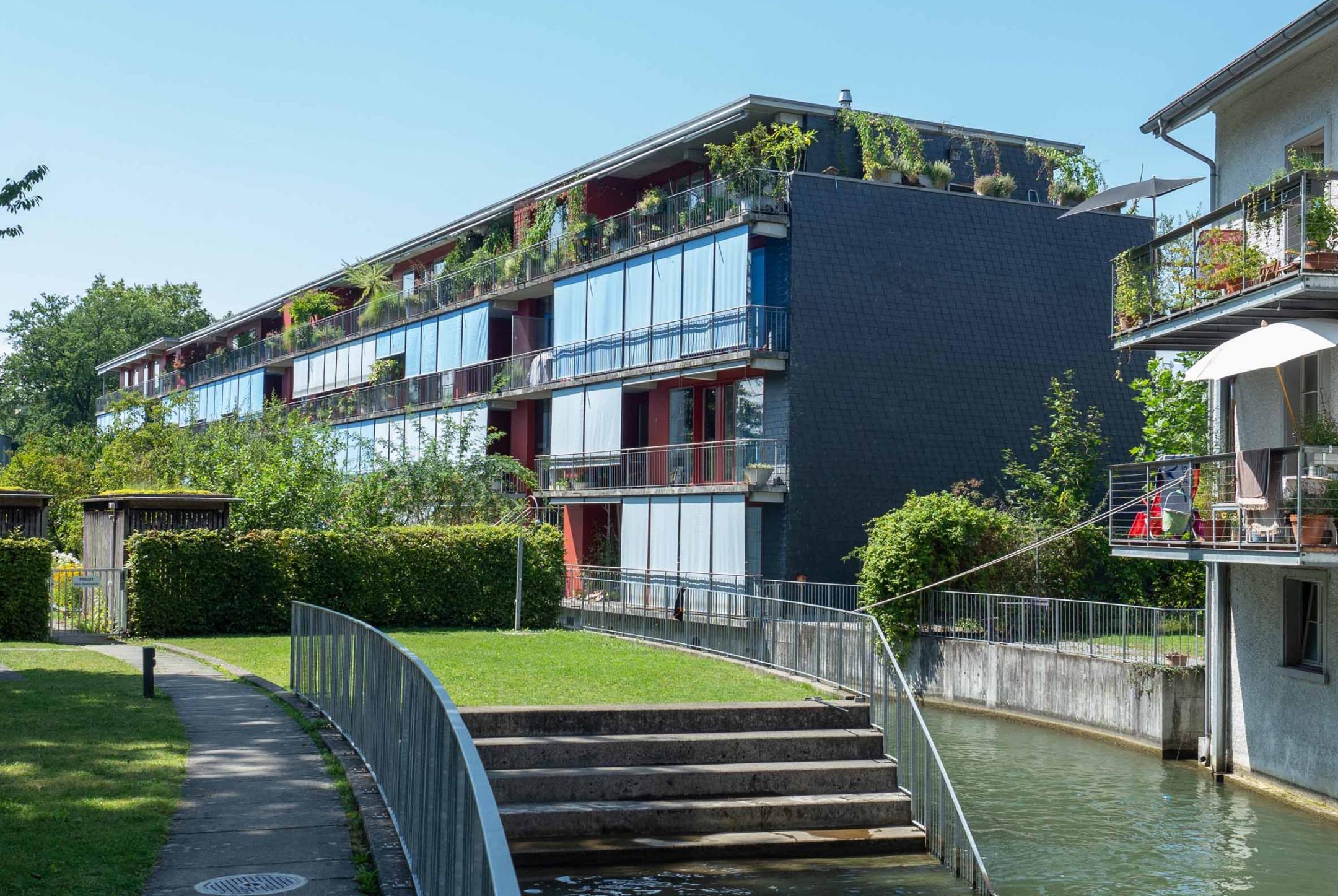 Uster, Im Lot: Zurückgesetzte sowie durch Bäume beschattete Fassaden und Sonnenstoren.