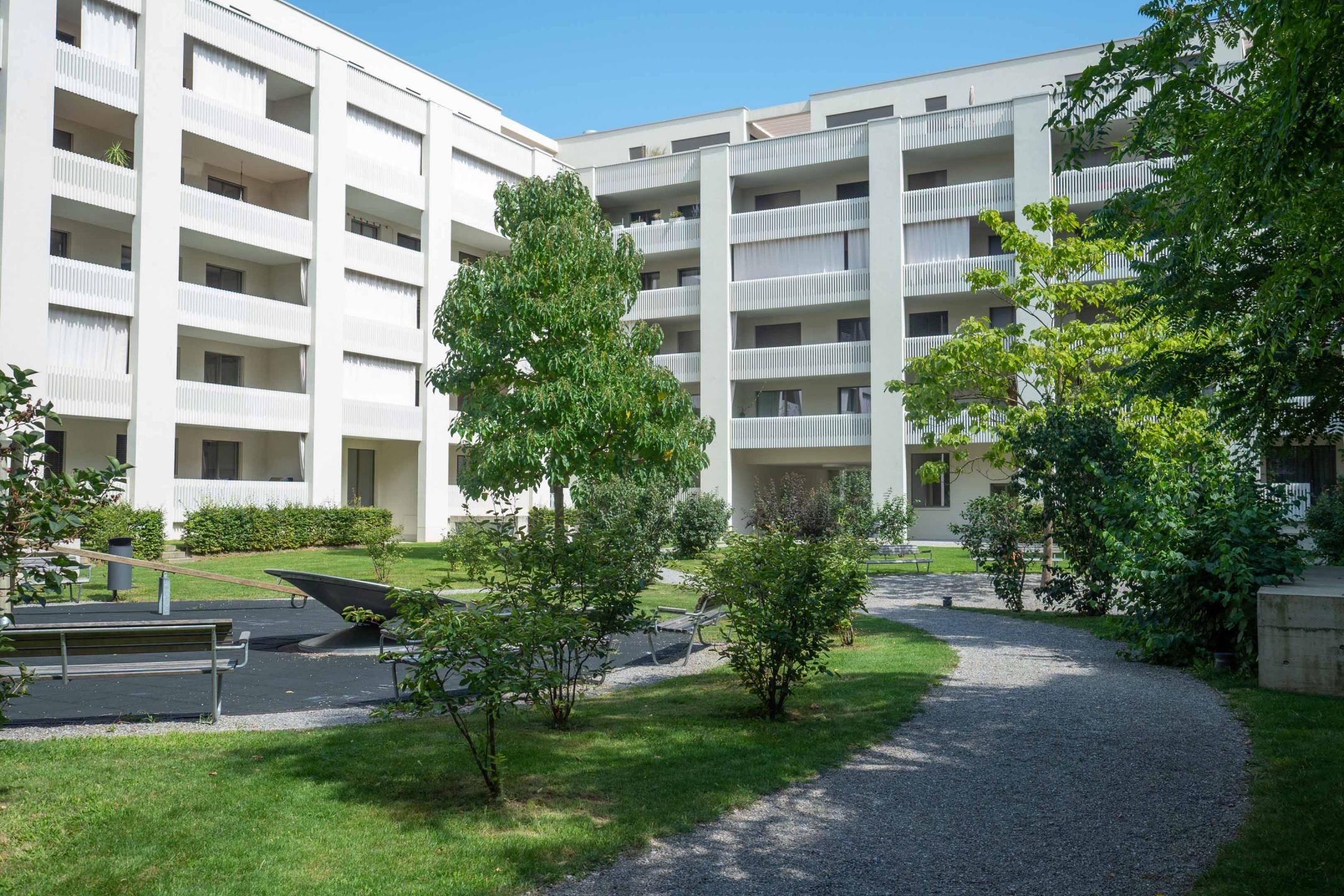 Wallisellen, Richti-Areal: Zurückgesetzte Fassaden, helle Oberflächen und Sonnenschutz.