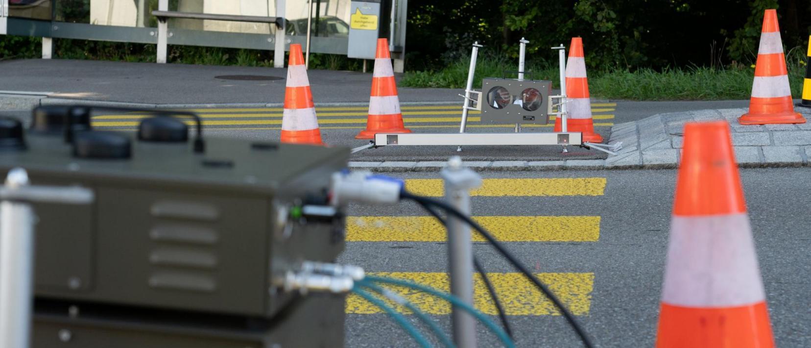 Blick auf Strasse mit Messgerät auf beiden Strassenseiten und Pillonen