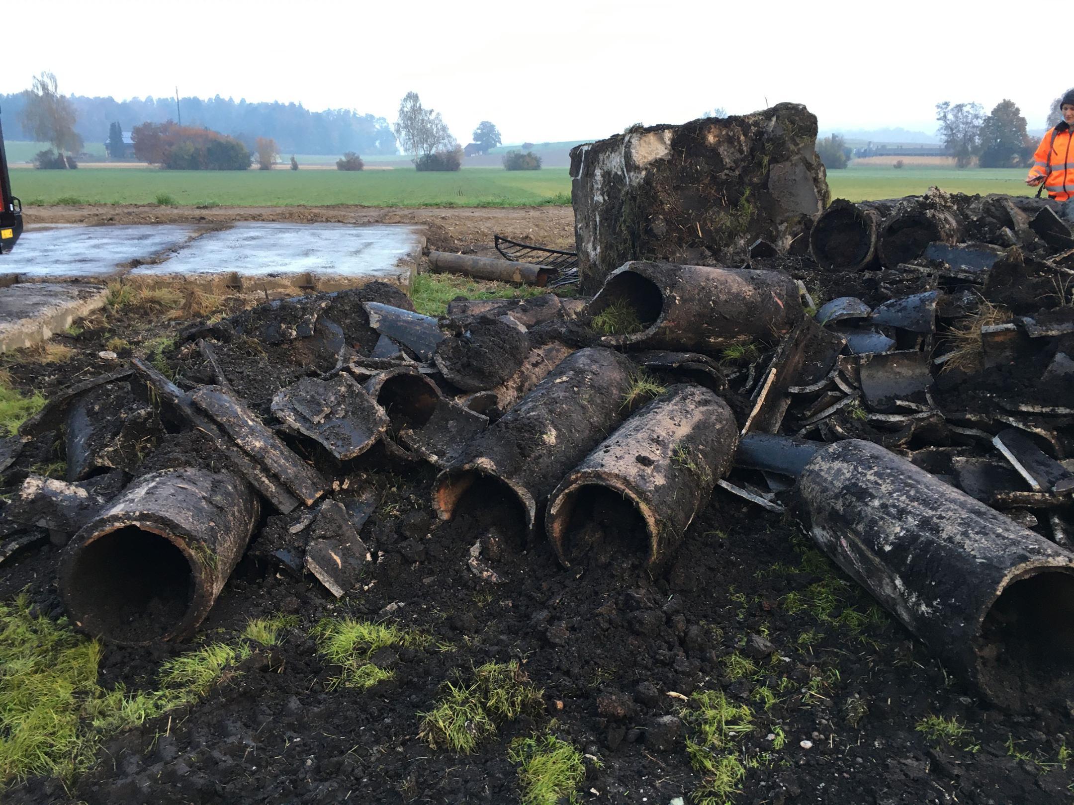 Ausgegrabene Entwässerungsrohre und -schächte auf einem Haufen.