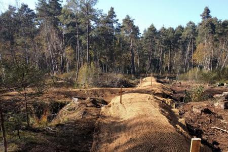 Mit einer Kokosmatte überzogener Hügel, unter der die Spundwand liegt
