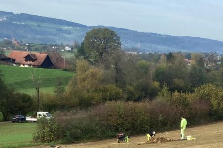 zwei Bauarbeitende kümmern sich um die Zwischenbegrünung, damit der offene Boden nicht erodiert.