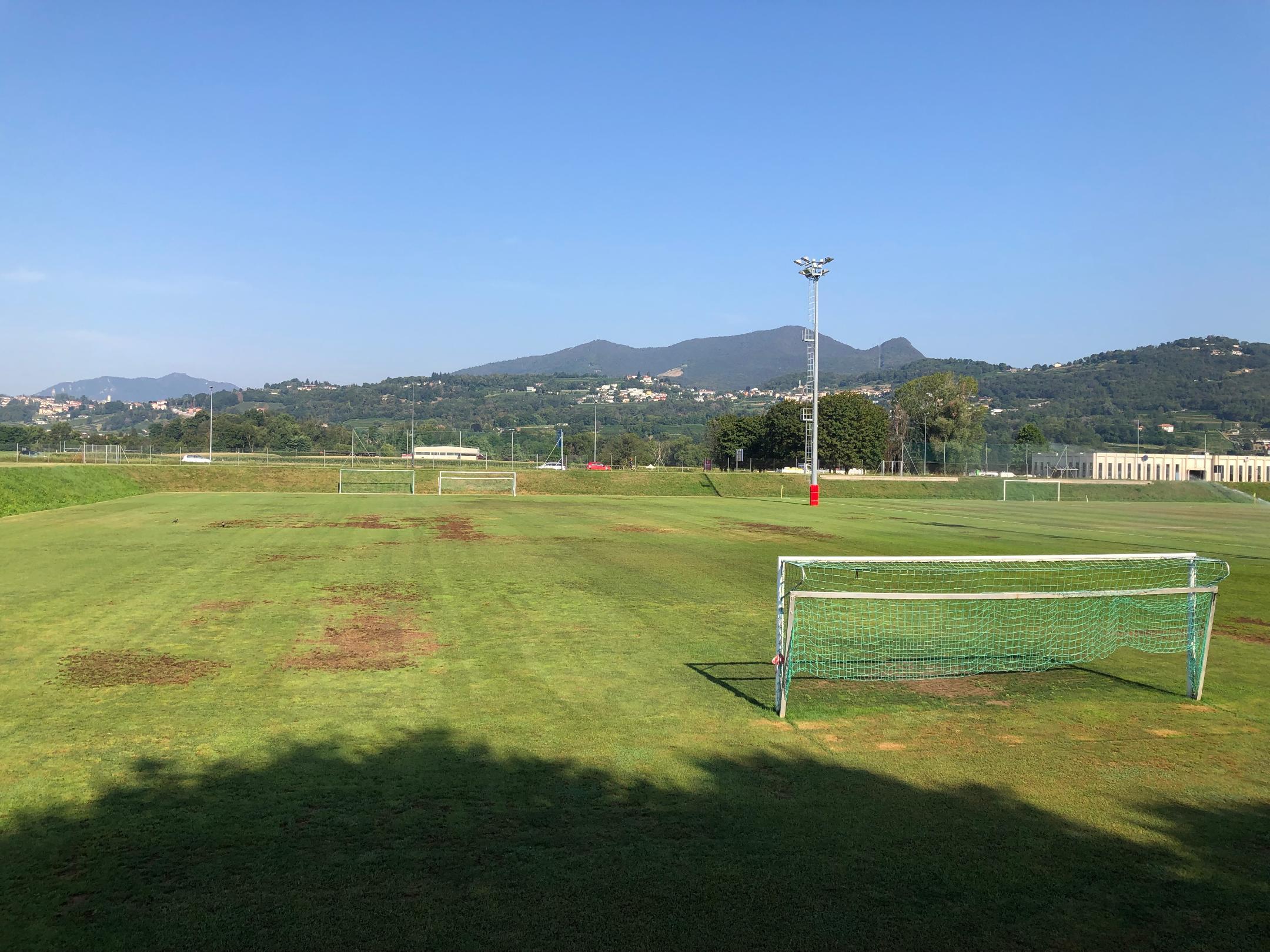 Fussballplatz mit mehreren braunen Stellen