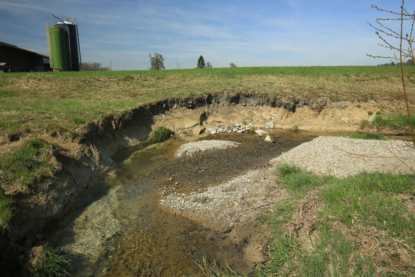 Ein natürlicher Bachlauf, der eine rechtwinklige Kurve einschlägt. Das Bachbett besteht aus Geröll. Auf der linken Uferseite ist ein steiler Prallhang, mit ausgeprägter Ufererosion. 