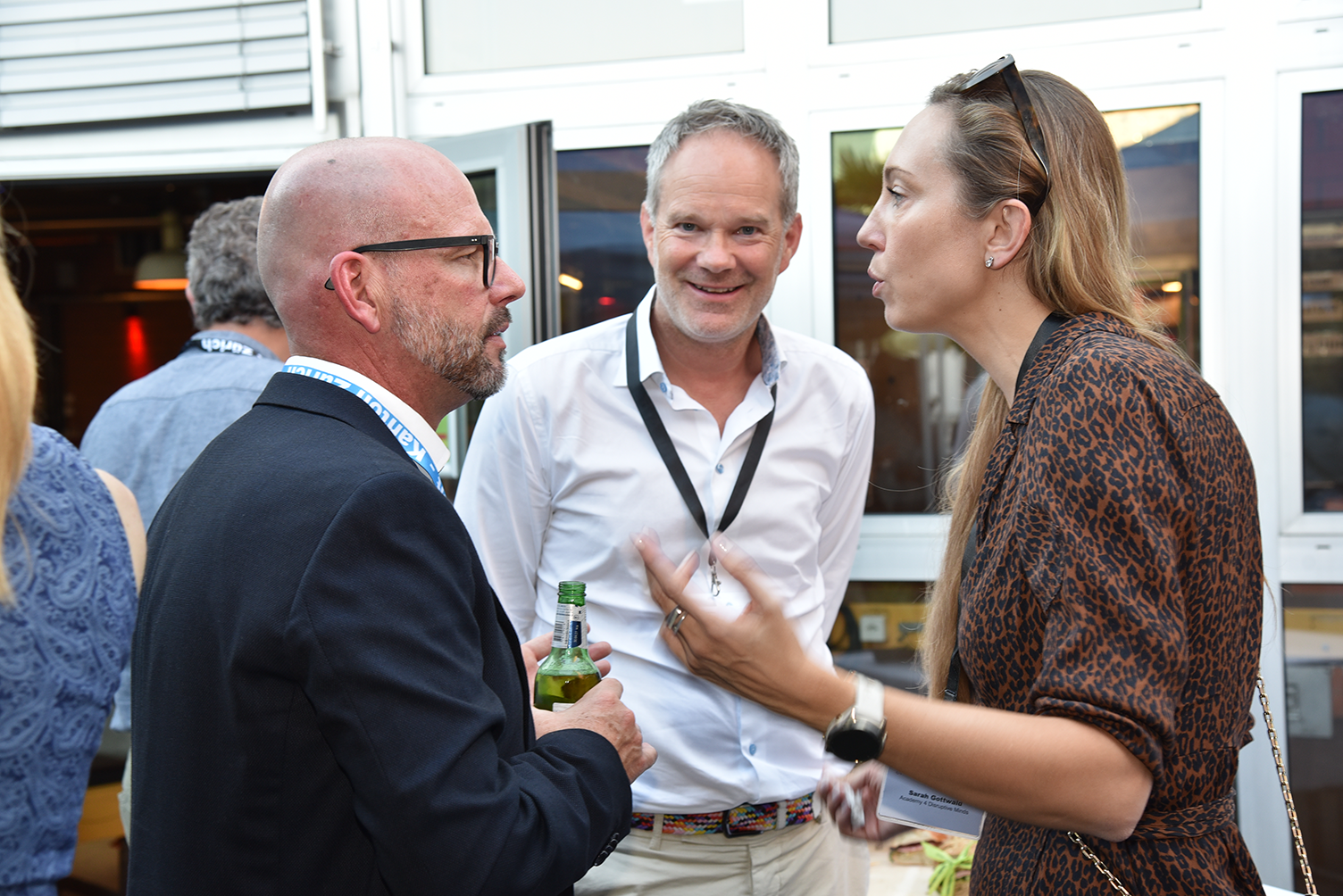 Eine Frau disktuiert mit zwei Männern am Networking-Apéro.