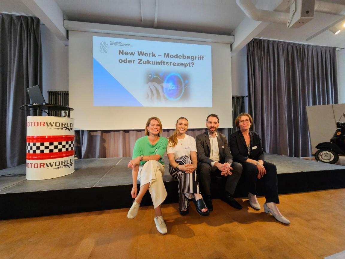 Saskia Baer, Flavia Huwyler, Luc Zobrist und Gisela Bolle sitzen auf dem Podium und lächeln in die Kamera