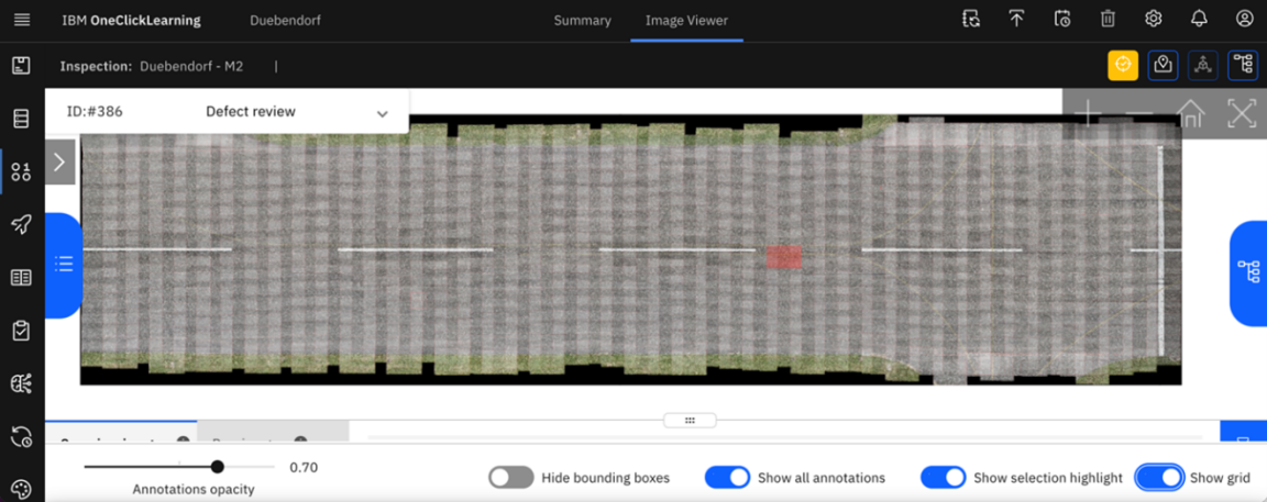 IBM OneClickLearning Dashboard zeigt ein asphaltierter Landebahnabschnitt mit gestrichelter Mittellinie mit einem kleinen rot eingefärbten Viereck von oben.